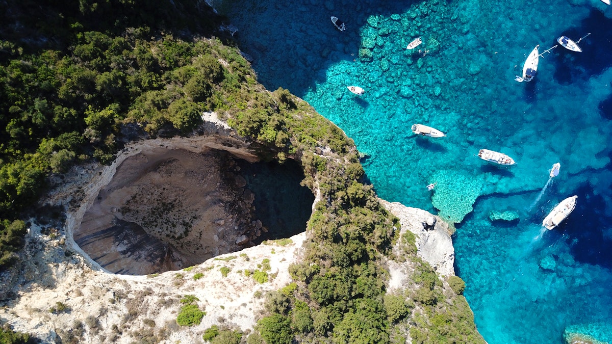 Imaginați-vă că vă aflați pe un iaht, plutind în derivă pe apele senine și azurii ale Mării Ionice, unde insulele Paxos și Antipaxos apar ca niște bijuterii de o frumusețe nealterată și un farmec liniștit. Sunteți pe cale să porniți în paradis.
