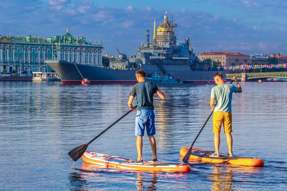Catedral de St. Isaac em São Petersburgo com navios de guerra ao fundo