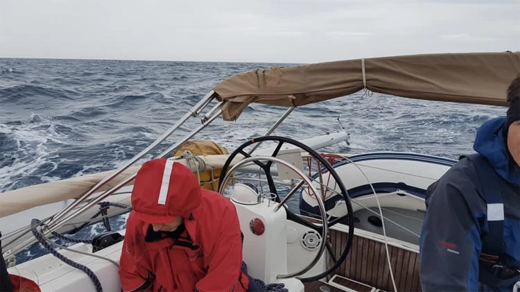 Collapsed mast tied to the side of the boat