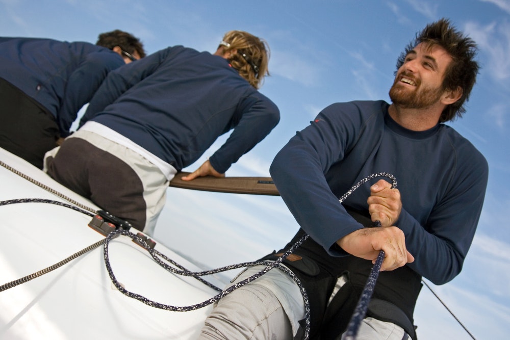  crew of men manoeuvring while yachting