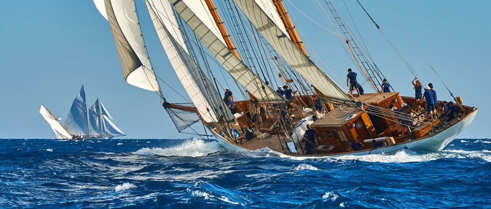 Regata de veleiros. Um veleiro clássico sob vela cheia numa regata.