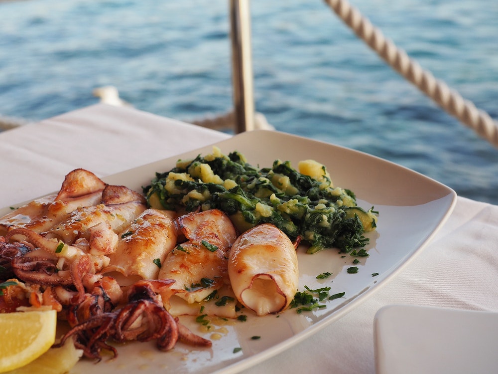 Anche i tradizionali calamari alla griglia croati sono serviti su un piatto.