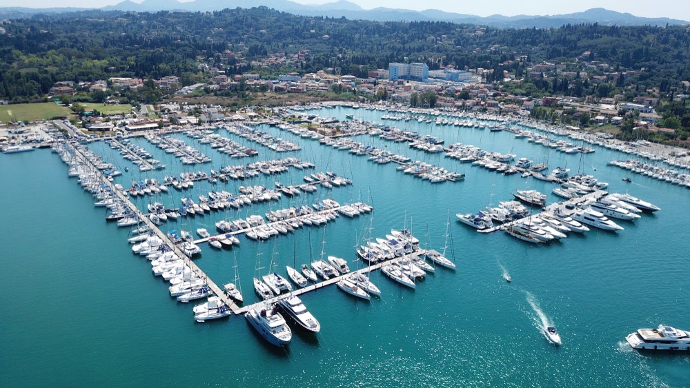 Der Yachthafen von Gouvia auf der Insel Korfu, Dutzende von Jachten, Segelbooten und anderen im Hafen verankerten Booten, die Landschaft im Hintergrund