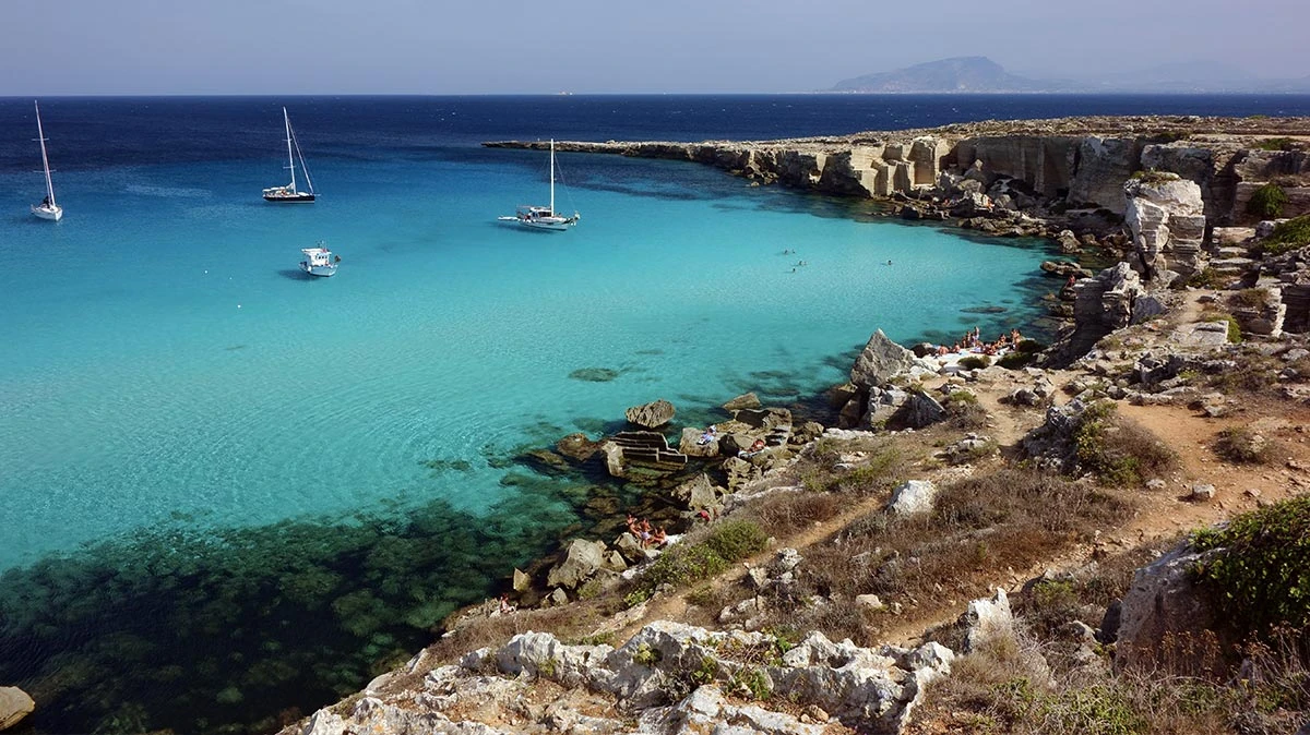 Den himmelsblå stranden i Cala Rossa, Sicilien