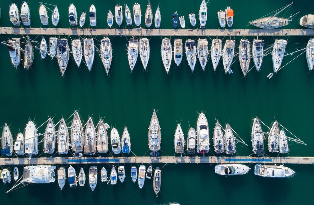 Паркинг за яхти. Марина, яхти и ветроходни лодки, закотвени на кея. 