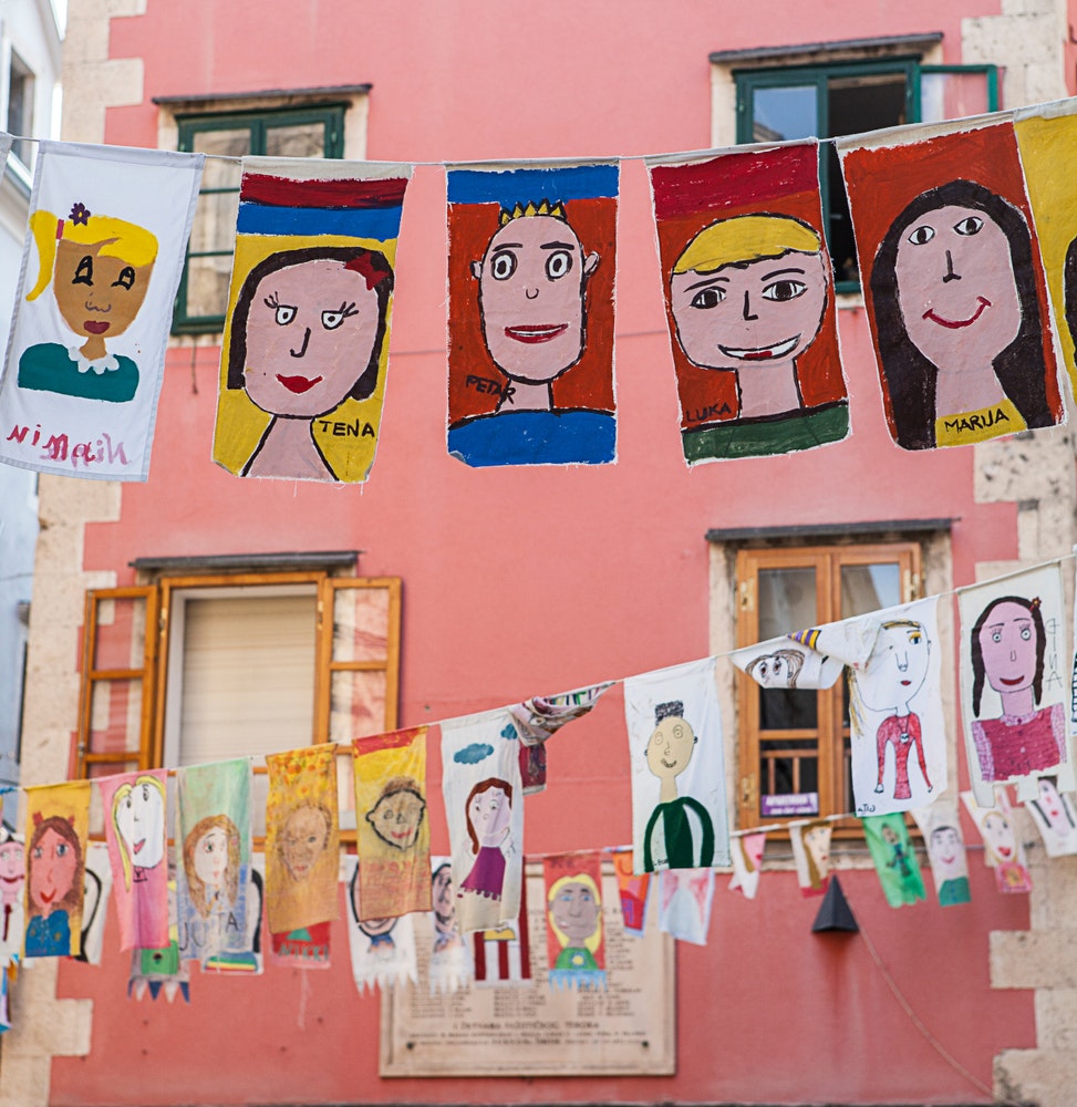 En vy av den historiska gamla staden under en konstfestival för barn. Staden är dekorerad med barns teckningar.
