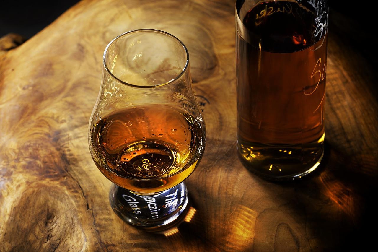 Bottiglia e bicchiere con whisky o rum