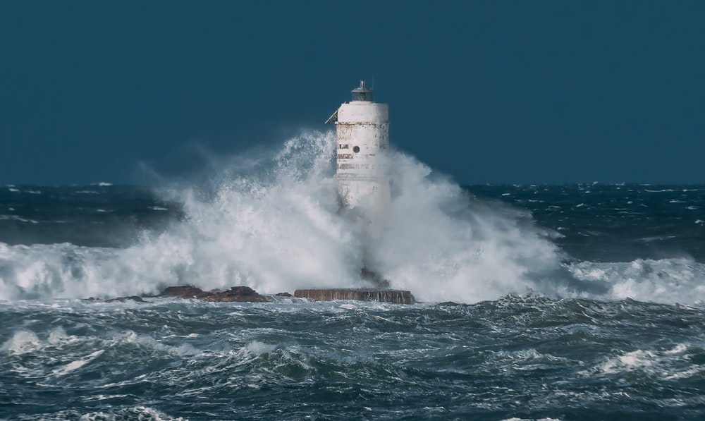 Faro di Mangiabarche con le grandi onde di una tempesta di vento che si infrangono contro di esso.