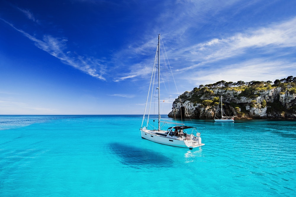 Krásná zátoka s plachetnicemi, ostrov Menorca, Španělsko