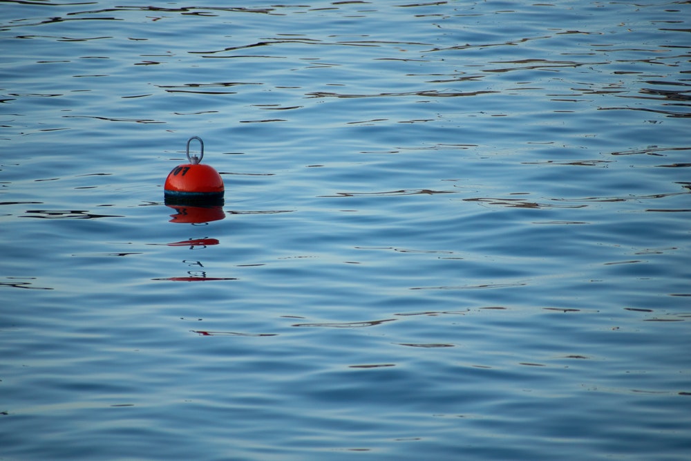 O geamandură roșie singuratică în mare.