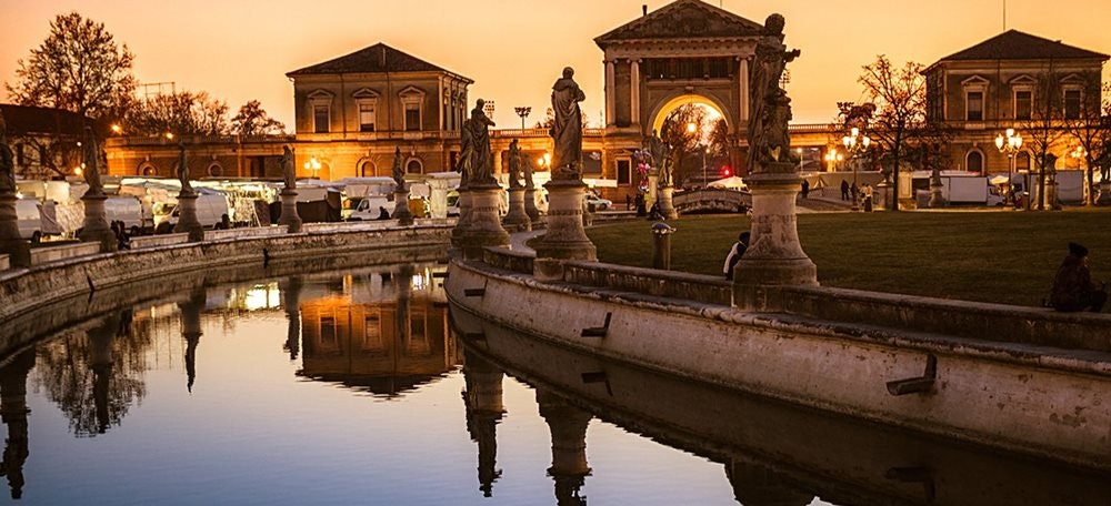Piazza Prato della Valle a Padova, al tramonto, canale d'acqua e statue
