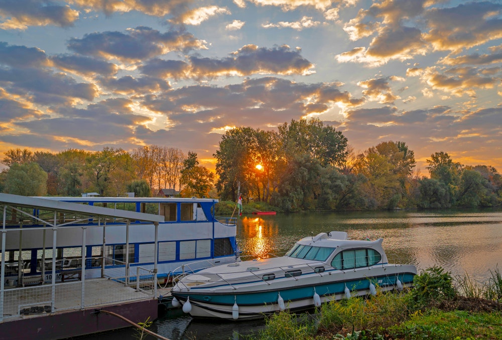 Vacker soluppgång vid floden Tisza med en husbåt förtöjd