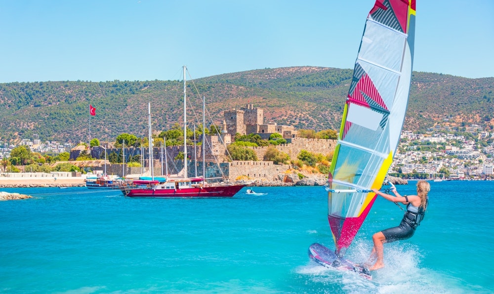 Skaistas zilas debesis ar vindsērfinga vēju uz viļņiem — Svētā Pētera pils (Bodrumas pils) un Bodrumas osta, Turcija