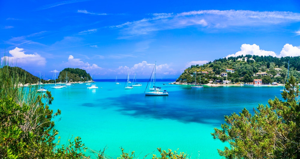 Lakka Bay, Paxos, türkisfarbenes Wasser, sonniges Wetter, Boote und Segelboote vor Anker in der Bucht