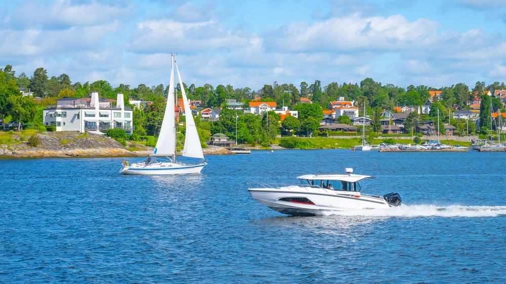 Ein Segelschiff und ein Motorboot segeln auf See vor der schwedischen Küste gegeneinander