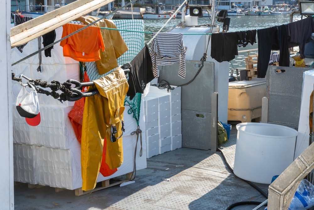 漁船のデッキで天日干しされている服。