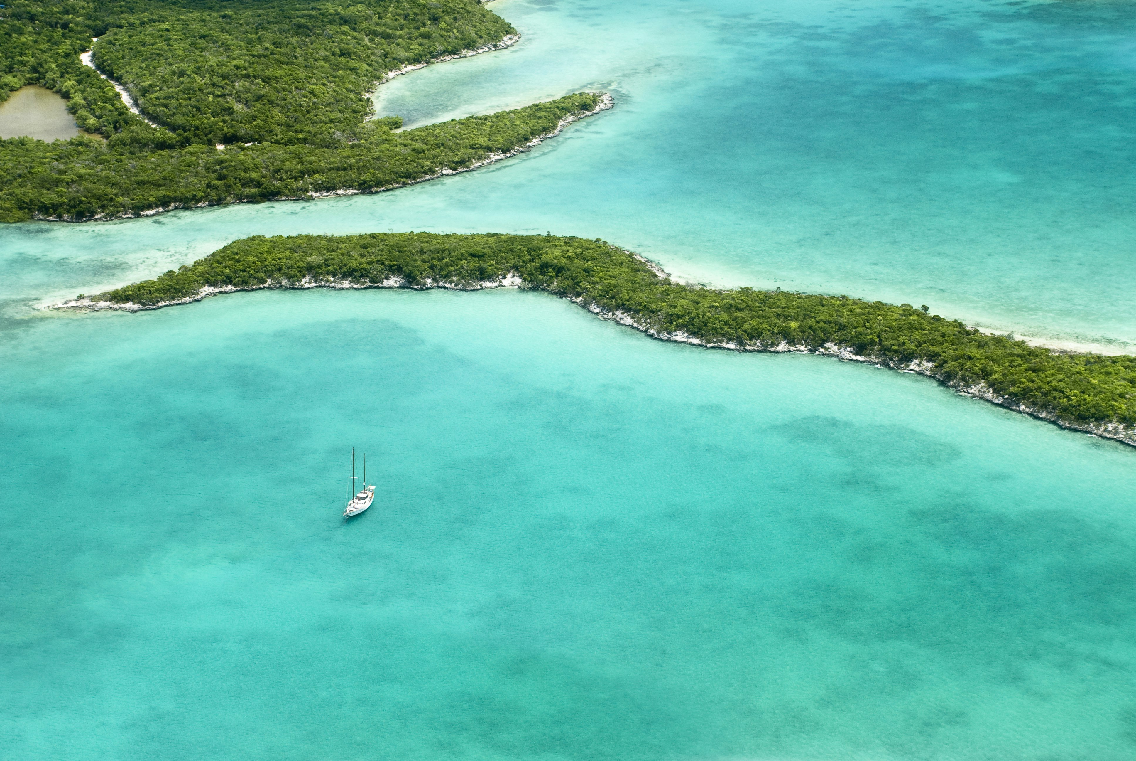 Pohled z ptačí perspektivy na část Bahamských ostrovů, plachetnici, pláže