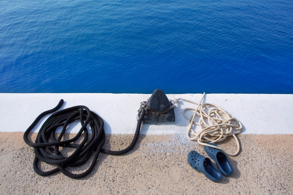 морско въже и ботуши в пристанището