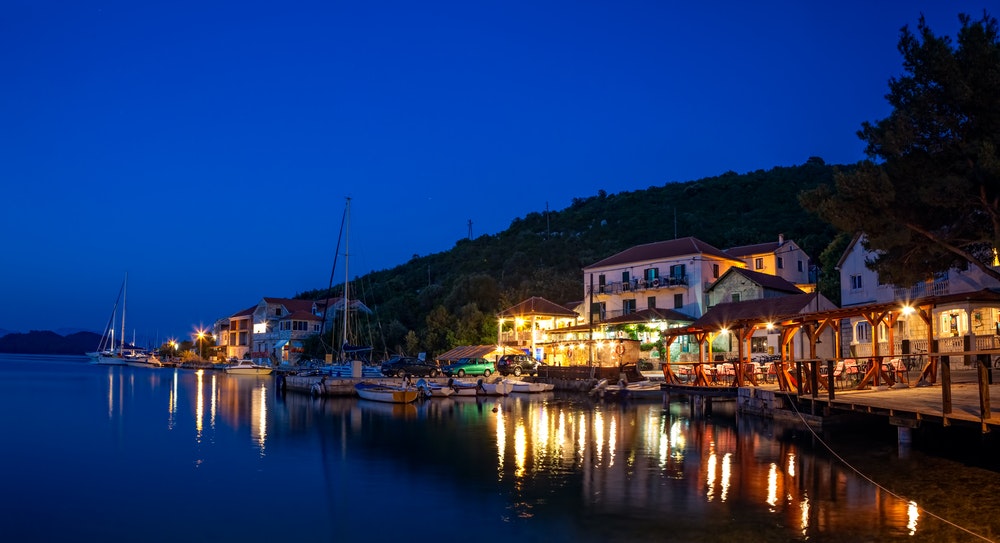 Лодки, закотвени пред ресторант в Хърватия, нощ и улично осветление