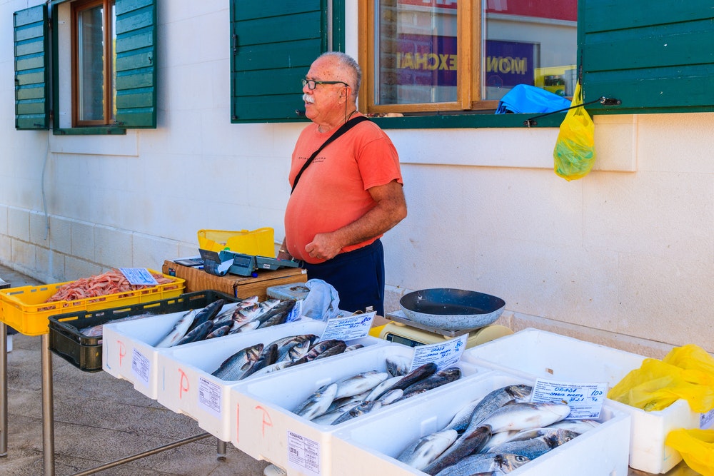 Een visser verkoopt zijn vangst in Primosten, Kroatië.