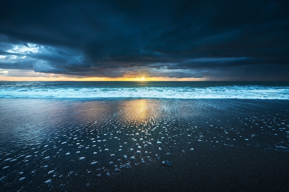 Šiurkščios jūros bangos ir putos po audros saulėlydžio metu