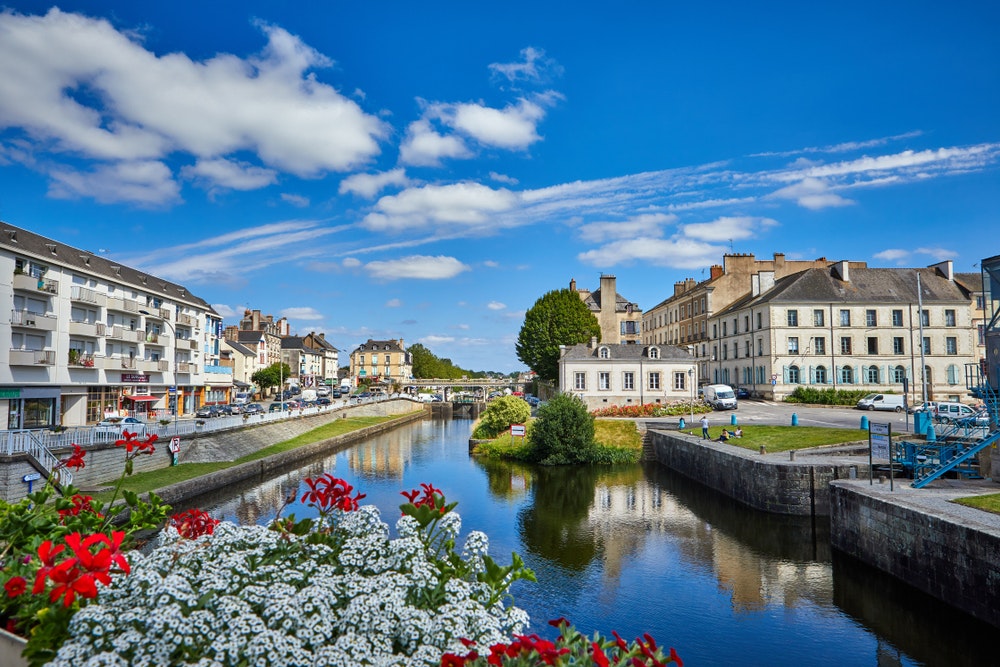 Изглед към водния канал в Редон, Бретан, Франция, слънчево време, мост, цветя.