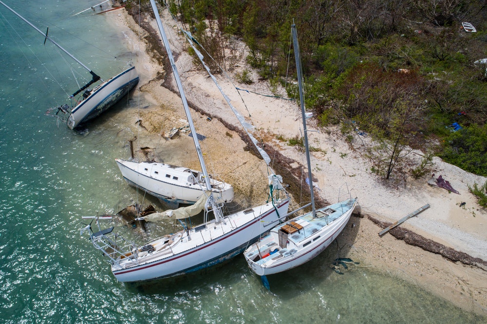 выброшенные на берег парусники, разбитые лодки после урагана