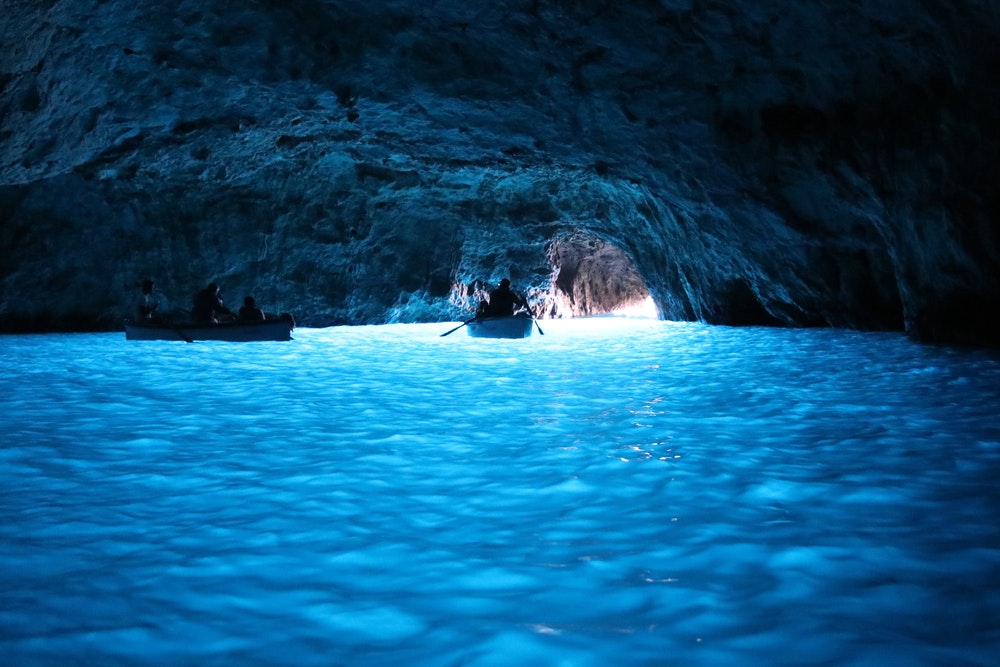 Modrá jaskyňa Grotta Azzurra na ostrove Capri s loďkami.