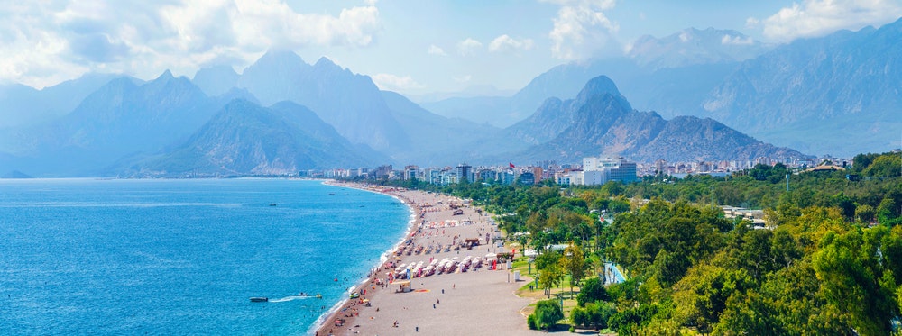Panoramautsikt över Antalya och Medelhavskusten, stranden och de vackra bergen i molnen.