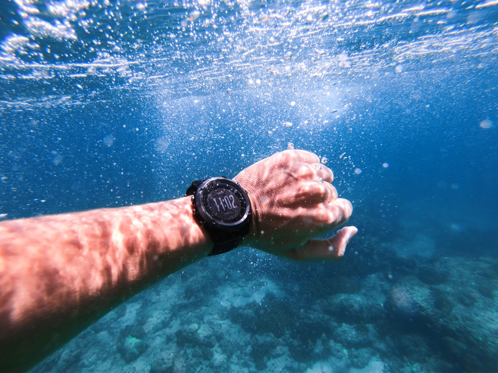 Sport chronograph on the hand under water. Diving accessory with GPS system.