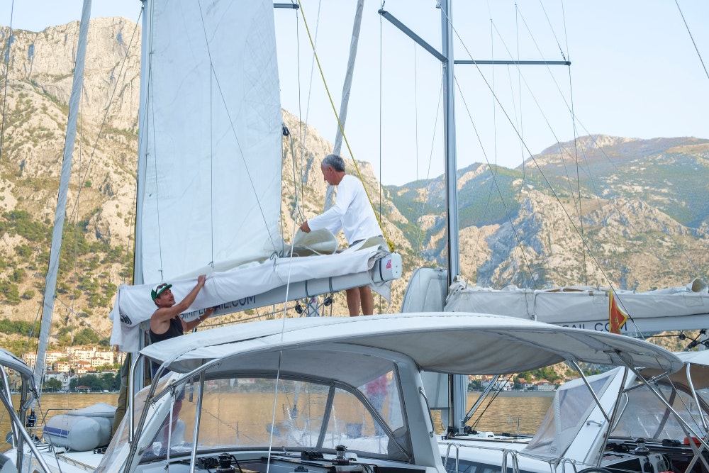 Sailors hoist the sails on a yacht to check them before going to sea.