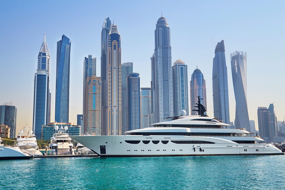Puerto deportivo de Dubai y yate de lujo, rascacielos al fondo