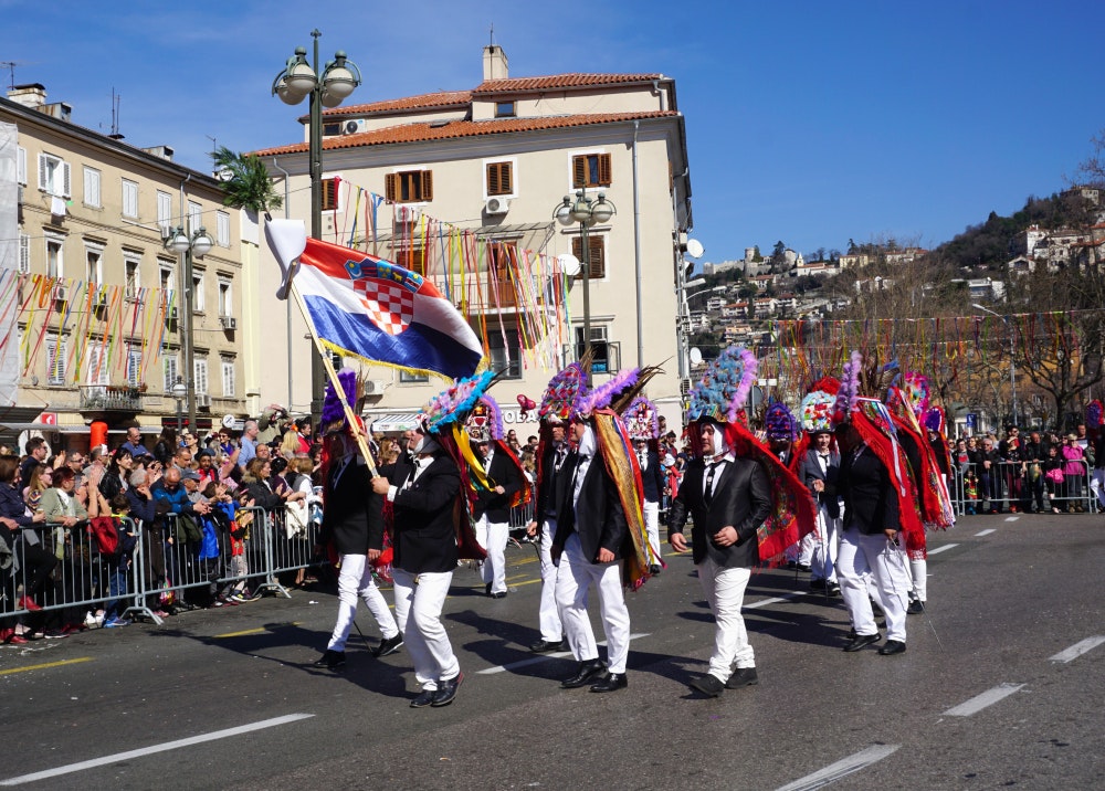 Rijeka, Kroatien, grupp män maskerade i traditionell kostym vid en karnevalsparad