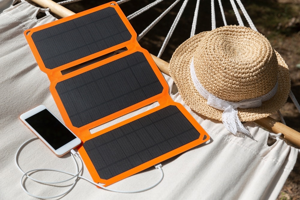 Ένα smartphone φορτίζεται με ηλιακή μπαταρία στην κατασκήνωση.