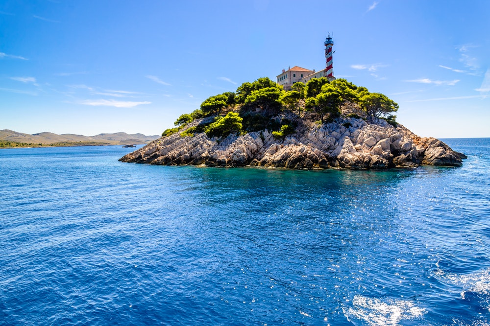 Isola rocciosa croata con faro a Vela Sestrica, vicino a Kornati, Mare Adriatico, Croazia,