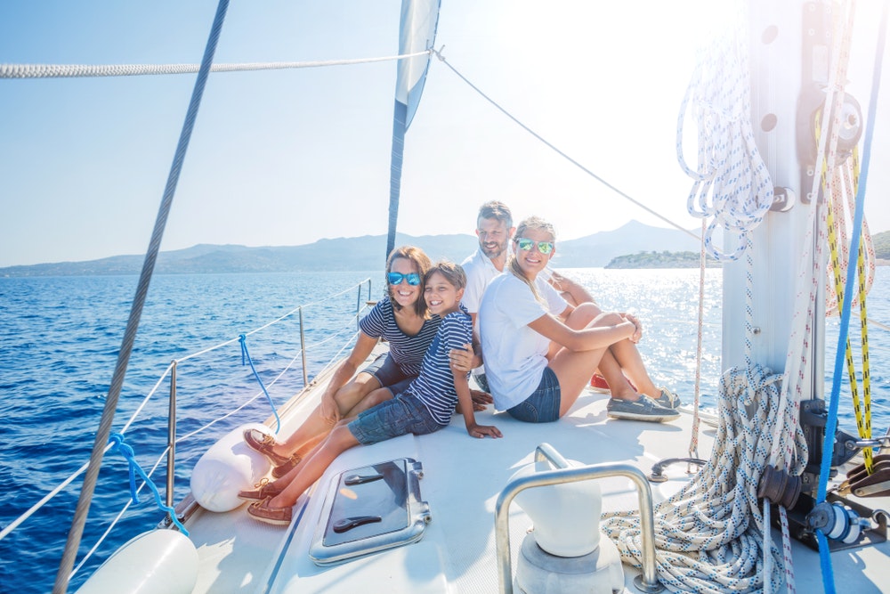 Happy family with daughter and son relaxing on a large yacht