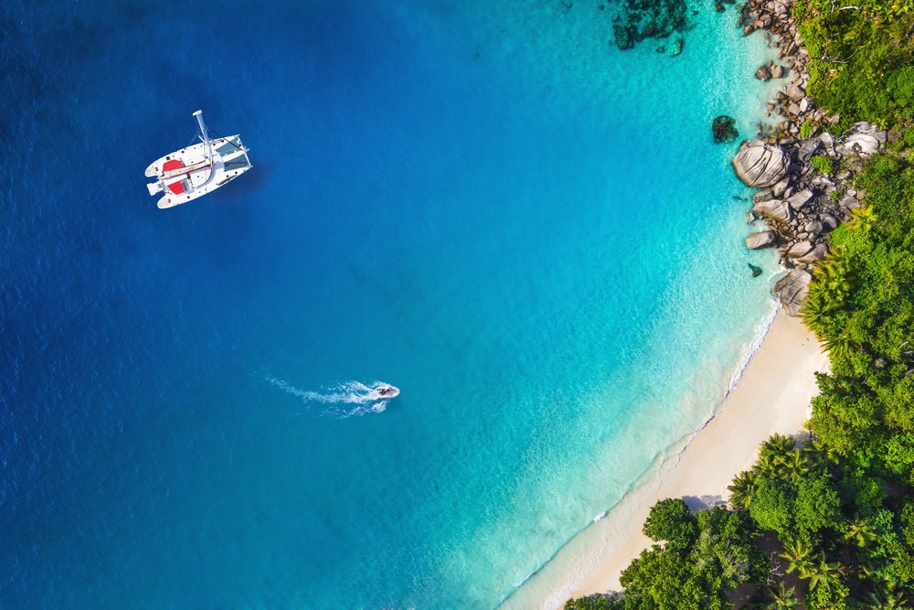 Úžasný pohľad na jachtu v zátoke s plážou, pohľad z dronu