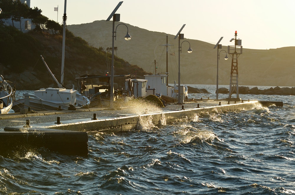 Piren i en hamn som piskas av smältvatten på västkusten av den grekiska ön Ios i Kykladernas skärgård.